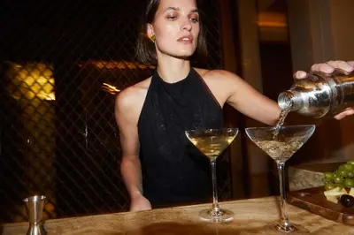 a woman pouring a glass of white wine at One&Only The Palm Dubai in Dubai