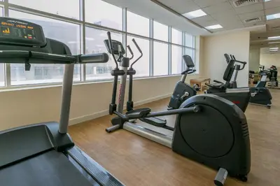 a gym with several treadmills and elliptical machines at Near Burj Khalifa, DownTown - Burj Al Nujoom in Dubai