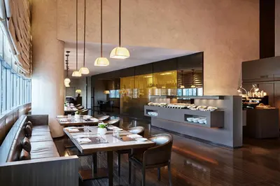 a restaurant with tables and chairs and a kitchen at Armani Hotel Dubai, Burj Khalifa in Dubai