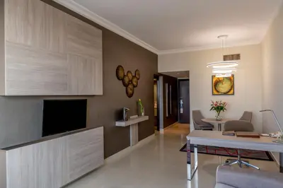 a living room with a television and a dining room at Two Seasons Hotel & Apartments in Dubai