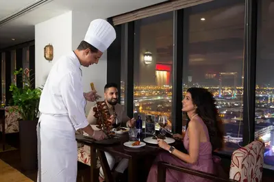 a chef preparing food at a table in a restaurant at Park Regis Kris Kin Hotel in Dubai
