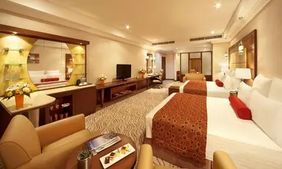 a hotel room with two beds and a mirror at Park Regis Kris Kin Hotel in Dubai