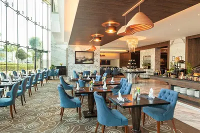 a restaurant with blue chairs and tables and a bar at voco - Bonnington Dubai by IHG in Dubai
