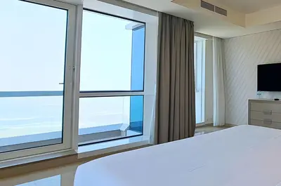a bedroom with a large bed and a large window at Barceló Residences Dubai Marina in Dubai