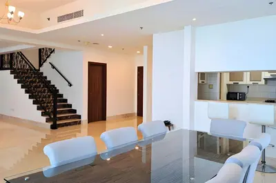 a dining room with white chairs and a glass table at Barceló Residences Dubai Marina in Dubai