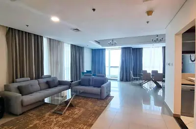 a living room with couches and a table and a kitchen at Barceló Residences Dubai Marina in Dubai