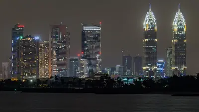 a city skyline at night with lit up buildings at Staybridge Suites Dubai Internet City by IHG in Dubai