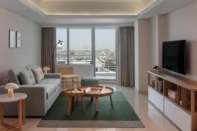 a living room with a couch and a tv at Staybridge Suites Dubai Internet City by IHG in Dubai