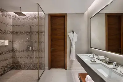 a bathroom with a shower and a sink and a mirror at The St. Regis Downtown Dubai in Dubai