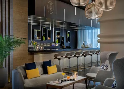 a bar in a hotel lobby with couches and chairs at voco Dubai by IHG in Dubai