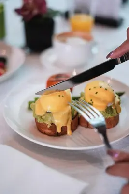a plate of food with a sandwich and a fork and knife at Ritz Carlton DIFC Downtown Dubai in Dubai