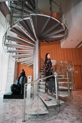 a woman standing on a staircase in a room at Ritz Carlton DIFC Downtown Dubai in Dubai