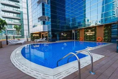 a large swimming pool in the middle of a building at Golden Tulip Media Hotel in Dubai