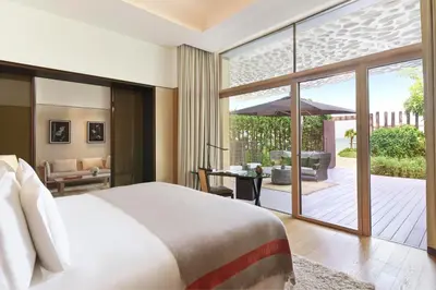 a bedroom with a bed and a patio with an umbrella at Bvlgari Resort Dubai in Dubai