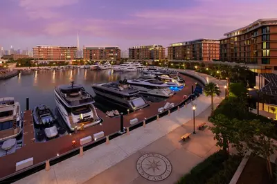 a group of boats docked in a marina at night at Bvlgari Resort Dubai in Dubai
