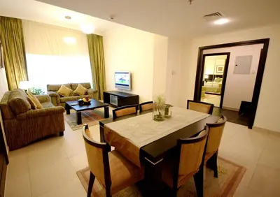 a living room with a table and chairs and a couch at Gulf Oasis Hotel Apartments Fz LLC in Dubai