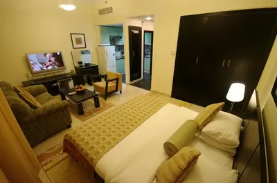a bedroom with a large bed and a living room at Gulf Oasis Hotel Apartments Fz LLC in Dubai