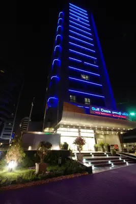 a tall building with blue lights on it at night at Gulf Oasis Hotel Apartments Fz LLC in Dubai