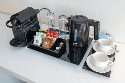 a black coffee maker and cups on a counter at Beach Walk Boutique Jumeirah in Dubai