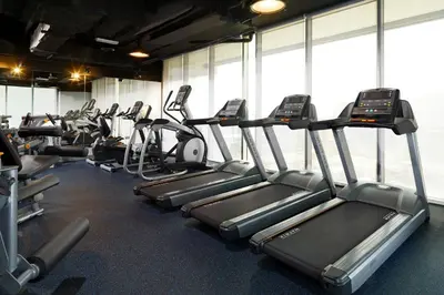 a gym with rows of treadmills and elliptical machines at Aloft Palm Jumeirah in Dubai