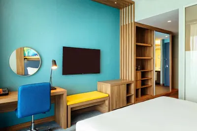 a room with a bed and a desk and a tv at Aloft Palm Jumeirah in Dubai