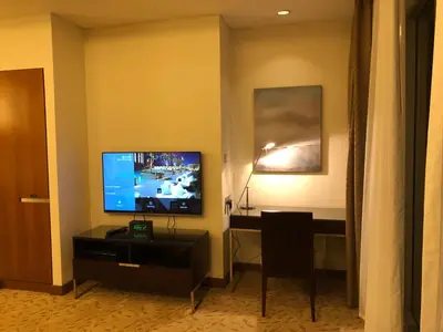 a living room with a television and a desk in a hotel room at Address Dubai Mall Fashion Avenue 1 bedroom 23 floor in Dubai