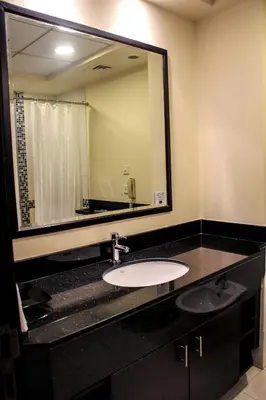 a bathroom with a sink and a large mirror at Dunes Hotel Apartment Oud Metha, Bur Dubai in Dubai