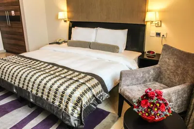 a hotel room with a large bed and a chair at Dunes Hotel Apartment Oud Metha, Bur Dubai in Dubai