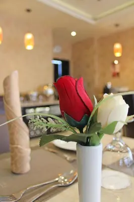 a white vase with red and white roses on a table at Dunes Hotel Apartment Oud Metha, Bur Dubai in Dubai