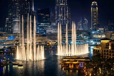 a group of water fountains in a city at night at Elite Royal Apartment - Full Burj Khalifa & Fountain view - Opal - 2 bedrooms plus 1 open bedroom without partition in Dubai