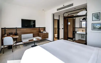 a bedroom with a bed and a desk and a television at FORM Hotel Al Jaddaf, Dubai, a Member of Design Hotels in Dubai