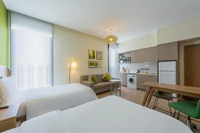 a hotel room with two beds and a kitchen at Element Me'aisam, Dubai in Dubai