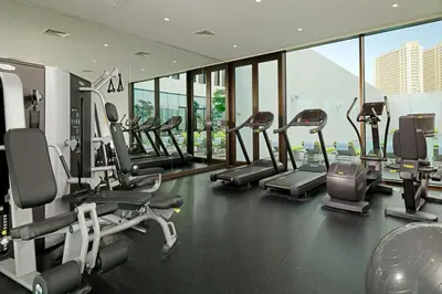 a gym with several treadmills and elliptical machines at Element Me'aisam, Dubai in Dubai