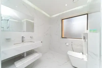 a white bathroom with a sink and a toilet at Jbr beach walk 2 bedrooms front sea in Dubai