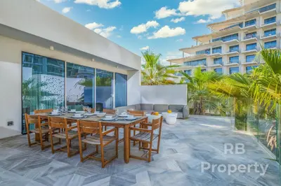 a dining room with a table and chairs and a building at FIVE Palm Beach Villa -Private Pool & Roopftop Jacuzzi, 3-Level, by Exclusive Holiday Homes in Dubai