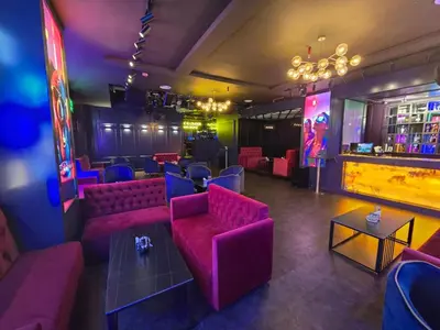 a room with purple couches and a bar with a bar at Gulf Inn Hotel Al Nasr Formerly Roda Links Al Nasr in Dubai
