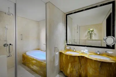 a bathroom with two sinks and a mirror and a tub at Crowne Plaza - Dubai Jumeirah by IHG in Dubai
