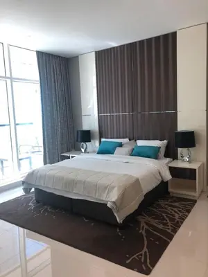 a bedroom with a large bed with blue pillows at Dubai Downtown View in Dubai