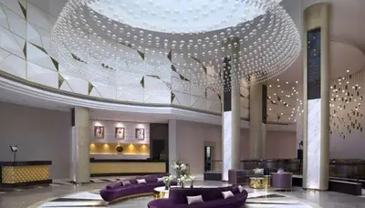 a large lobby with purple couches and a large chandelier at Dubai Downtown View in Dubai