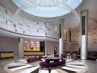 a large lobby with purple couches and a large chandelier at Dubai Downtown View in Dubai