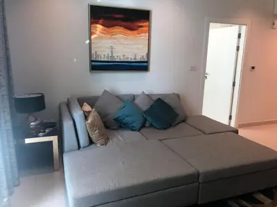 a living room with a couch with blue pillows at Dubai Downtown View in Dubai