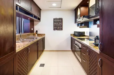 a large kitchen with wooden cabinets and a sink at One Bedroom Apartment Dubai Fountain & Old Town View by Auberge in Dubai