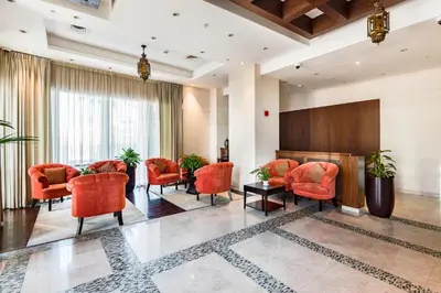 a lobby with orange chairs and a waiting room at One Bedroom Apartment Dubai Fountain & Old Town View by Auberge in Dubai
