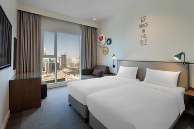 a hotel room with two beds and a large window at Rove Dubai Marina in Dubai