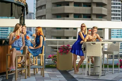 a group of people sitting at a table on a patio at Marina Byblos Hotel in Dubai