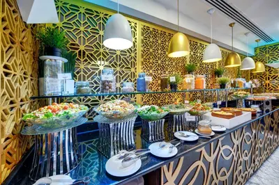 a buffet line with bowls of food in a restaurant at Gevora Hotel in Dubai