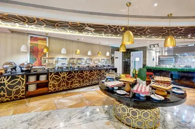 a restaurant with a counter with food on it at Gevora Hotel in Dubai