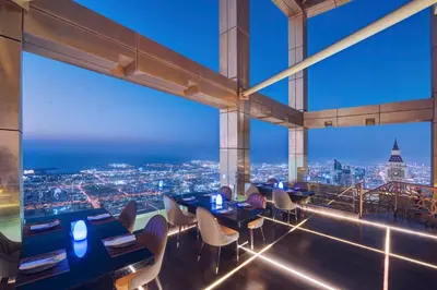 a restaurant with views of the city at night at Gevora Hotel in Dubai