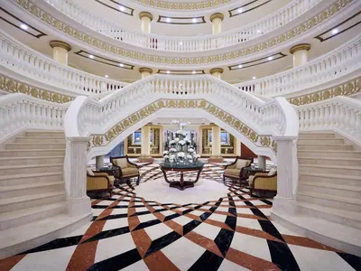an ornate lobby with a large staircase and a large room at Kempinski Hotel Palm Jumeirah in Dubai