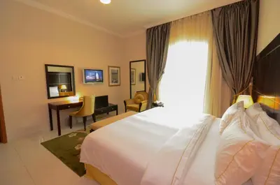 a hotel room with a bed and a desk and a window at Coral Boutique Villas in Dubai